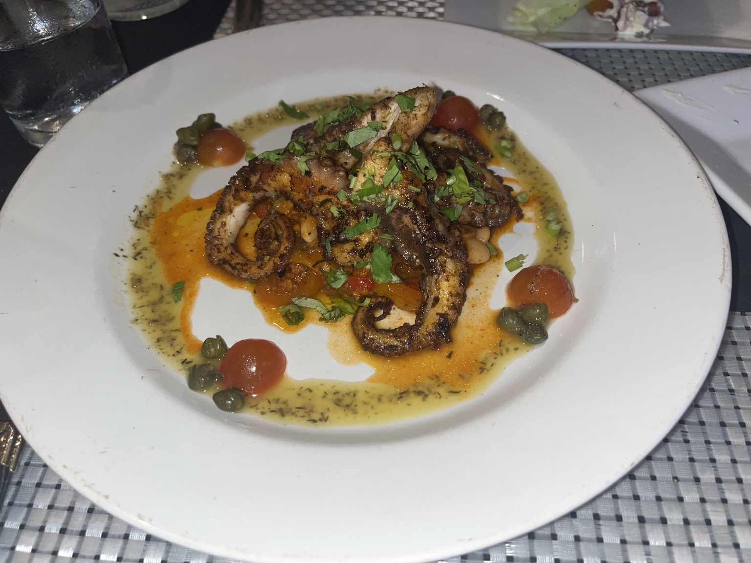 Grilled octopus tentacles with capers, cherry tomatoes and herb sauce
