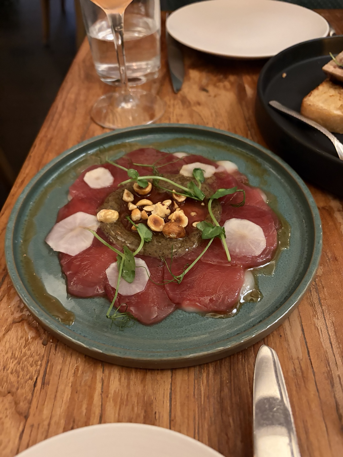 Carpaccio with savory puree, radish, toasted hazelnuts and greens