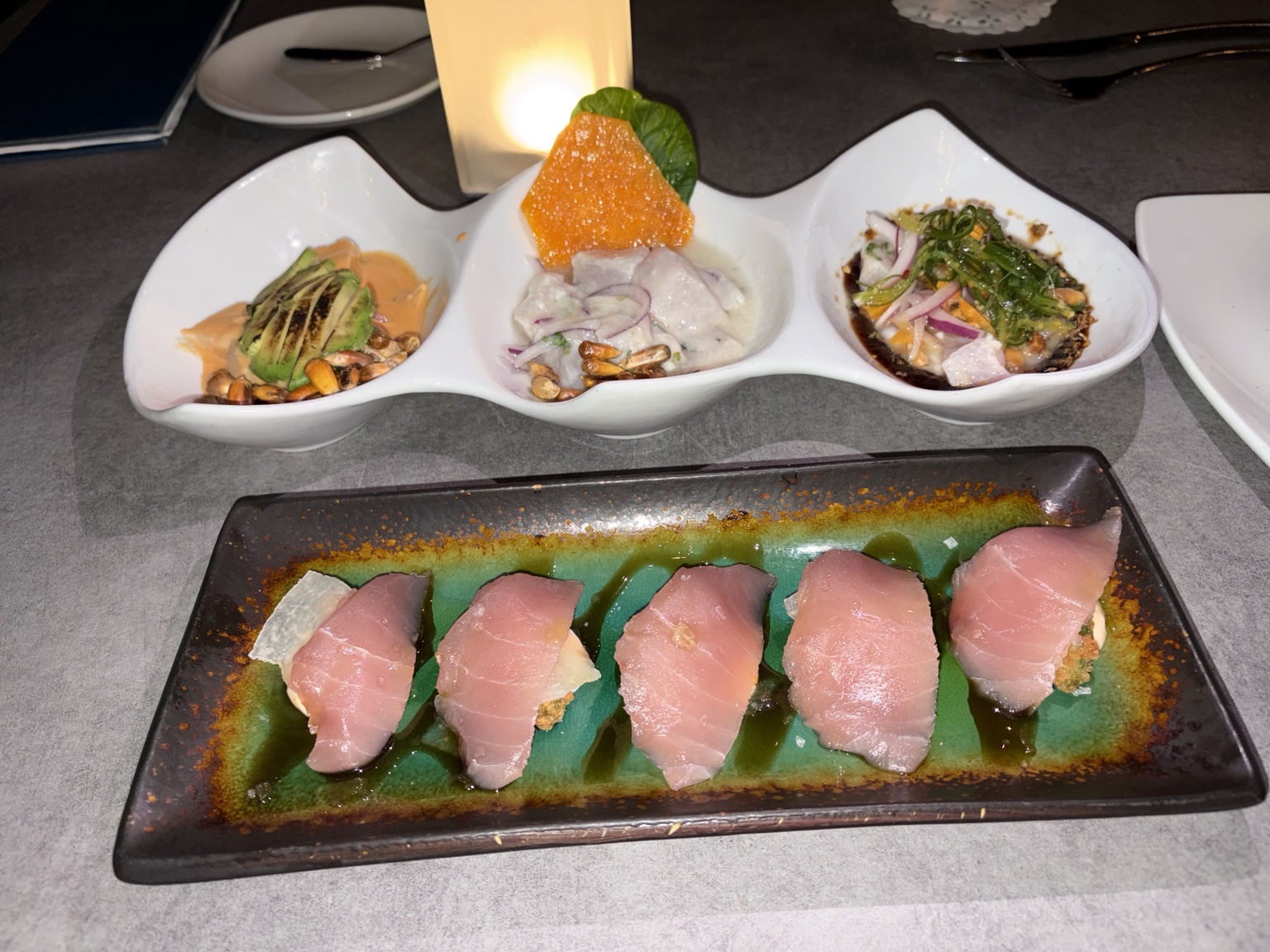 Pink-fish nigiri served with three small seafood preparations