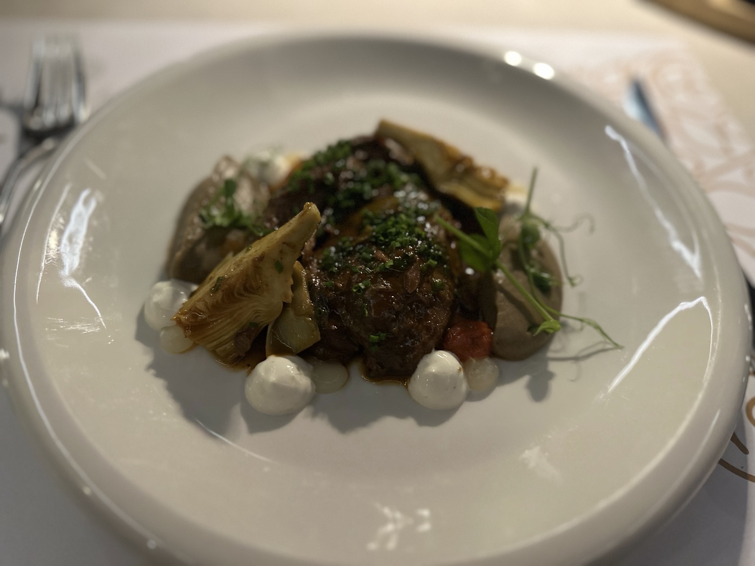 Braised beef with artichoke hearts, puree, herbs and creamy sauce