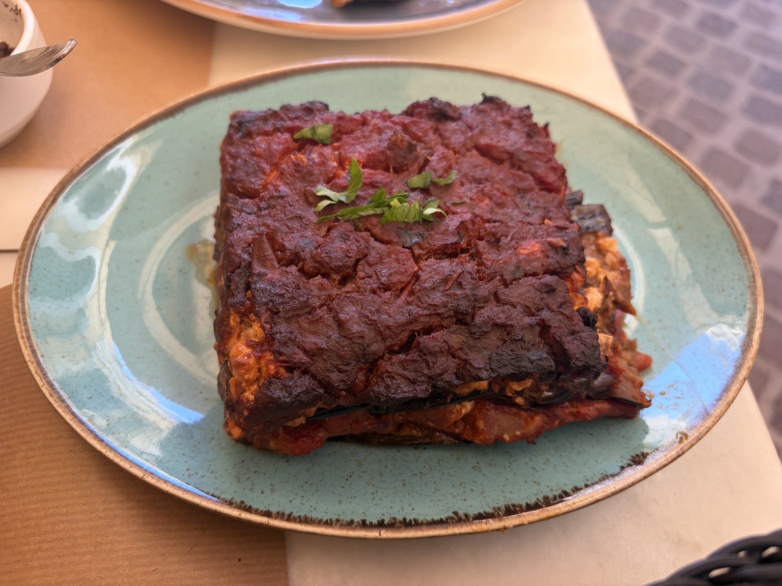 Square slice of layered moussaka with a deeply browned top