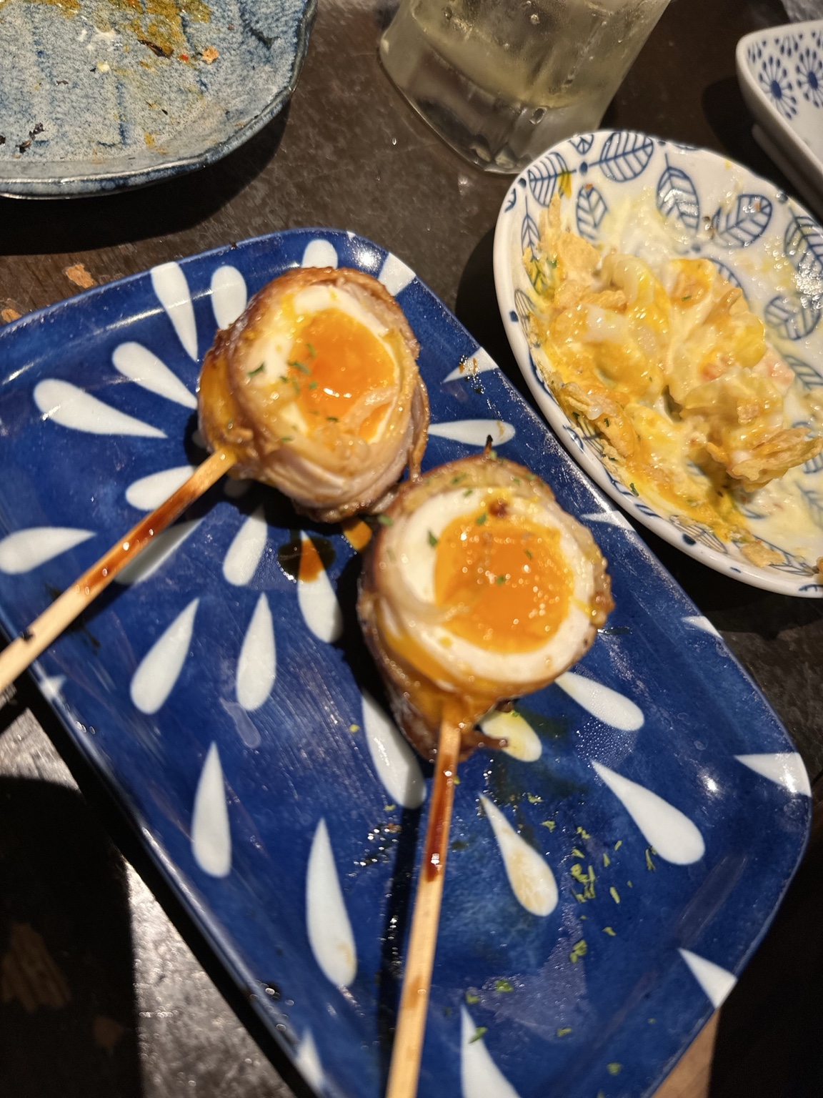 Bacon-wrapped soft-boiled eggs served on skewers