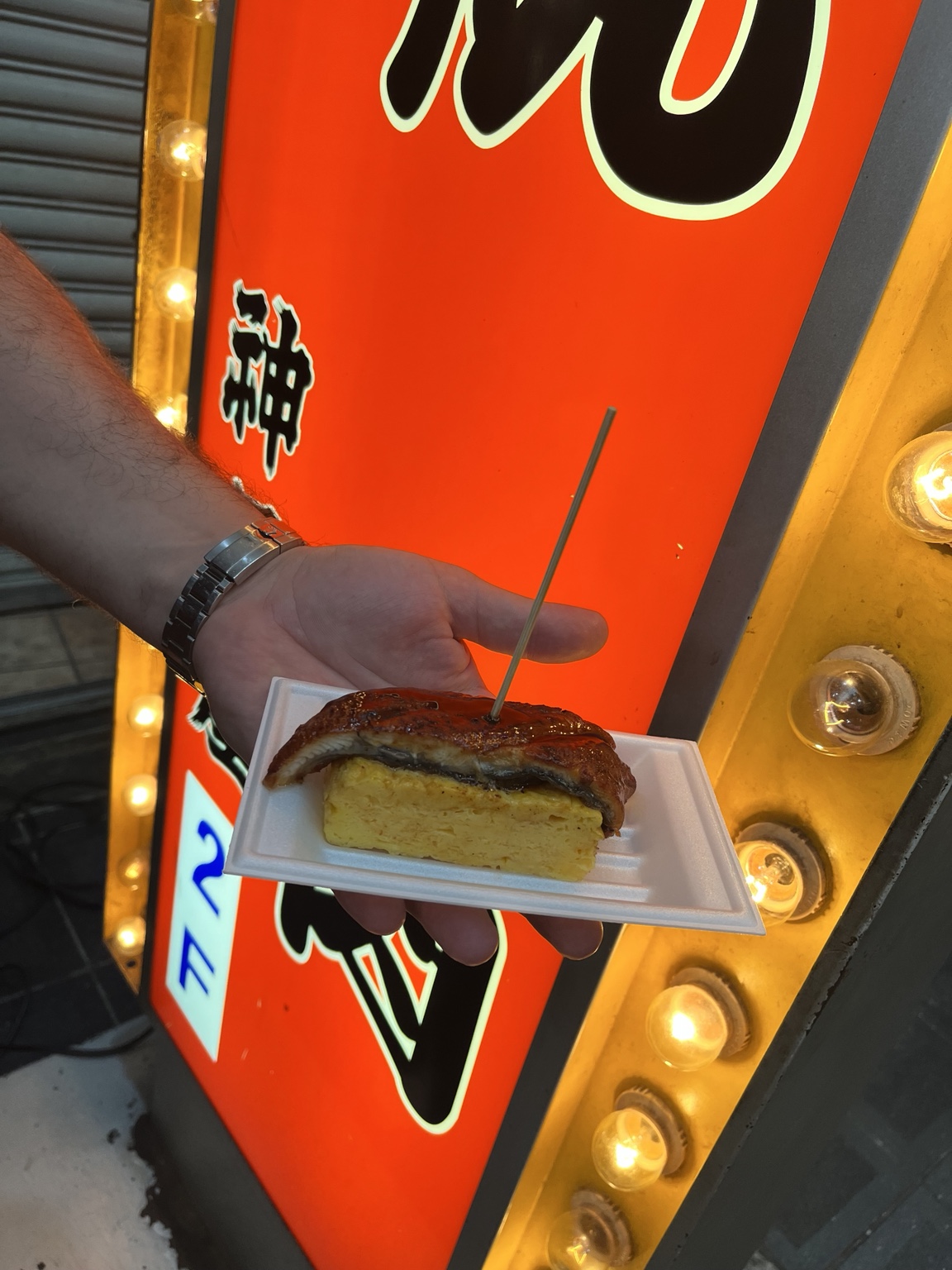 Rolled omelet topped with a glossy piece of grilled eel