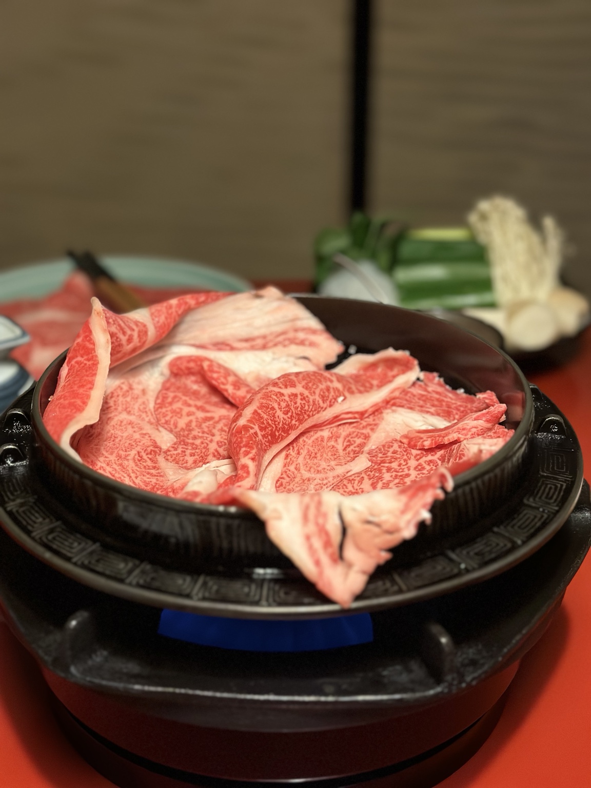 Thin slices of marbled beef arranged in a hot pot