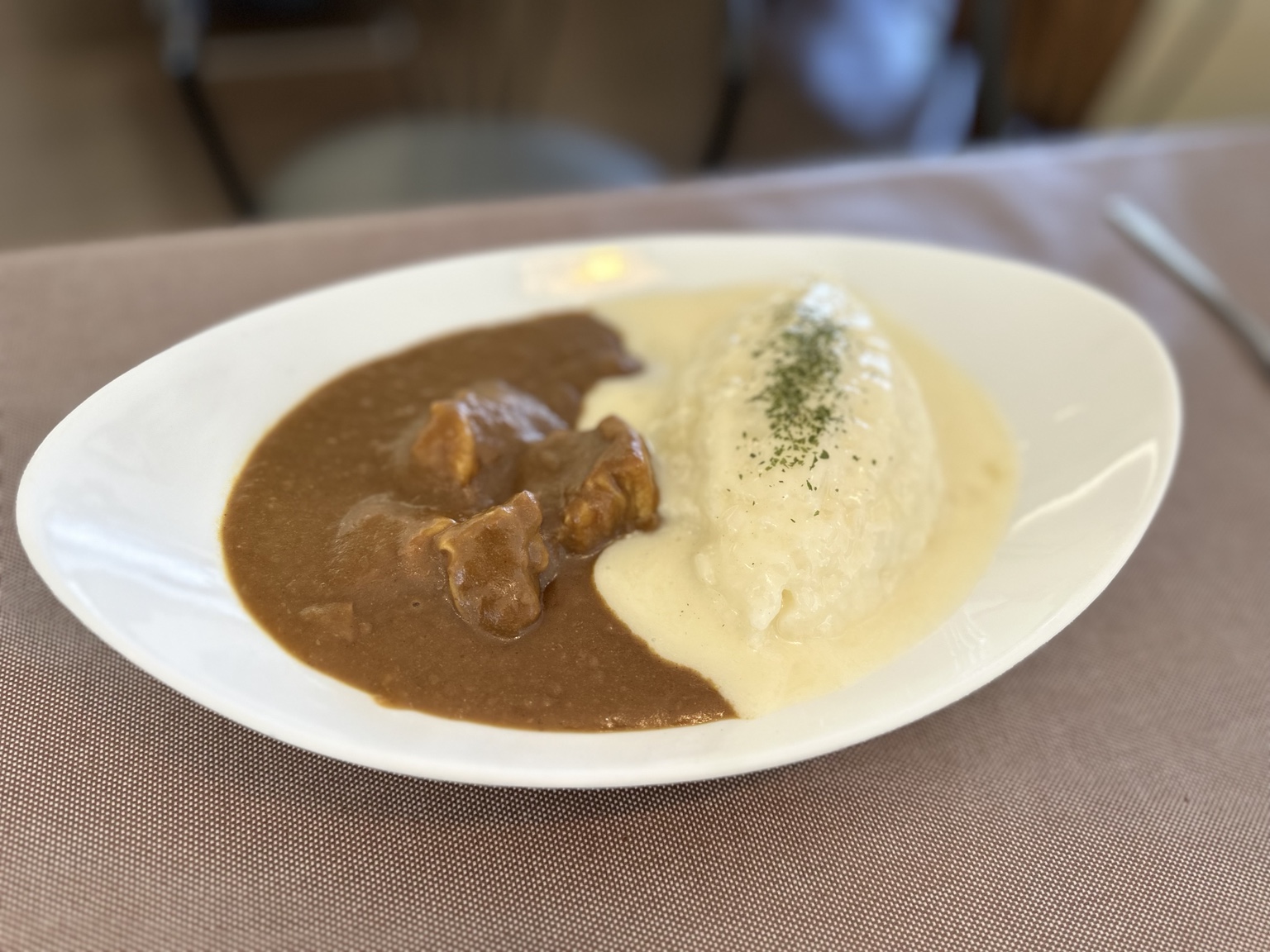 Omelet-covered rice served with Japanese curry and creamy sauce