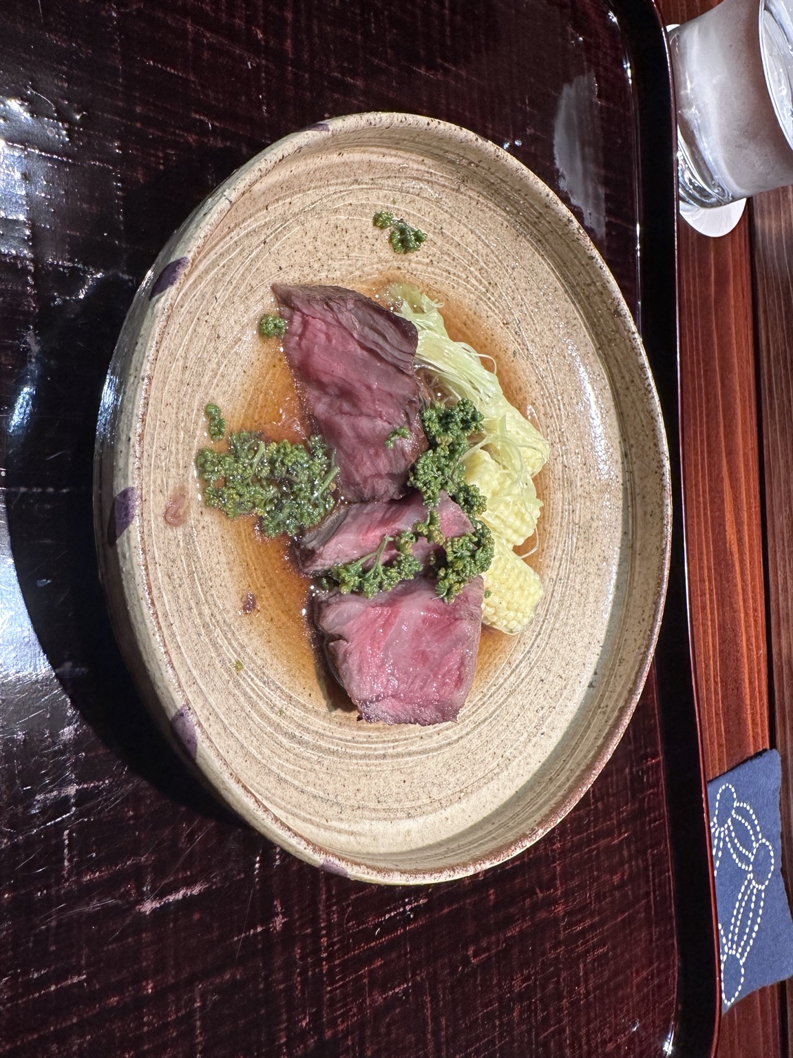 Slices of rare beef with shredded vegetables and green garnish