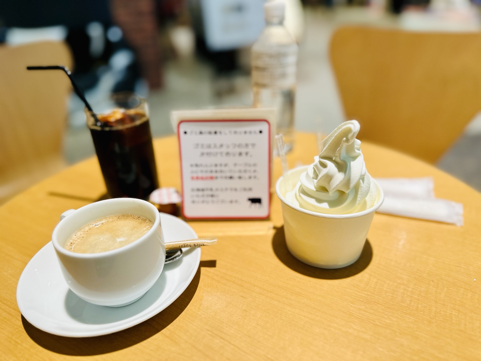 Cup of soft-serve ice cream beside a cup of coffee