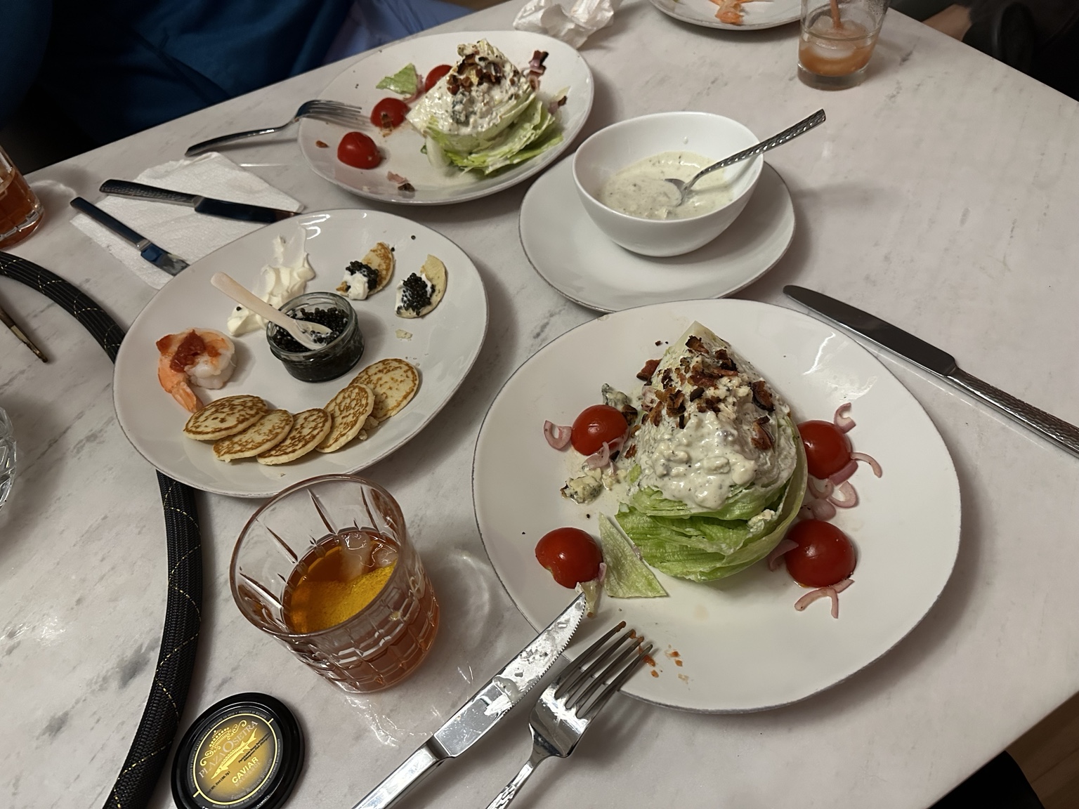 Caviar with small pancakes, shrimp, creamy soup and wedge salads