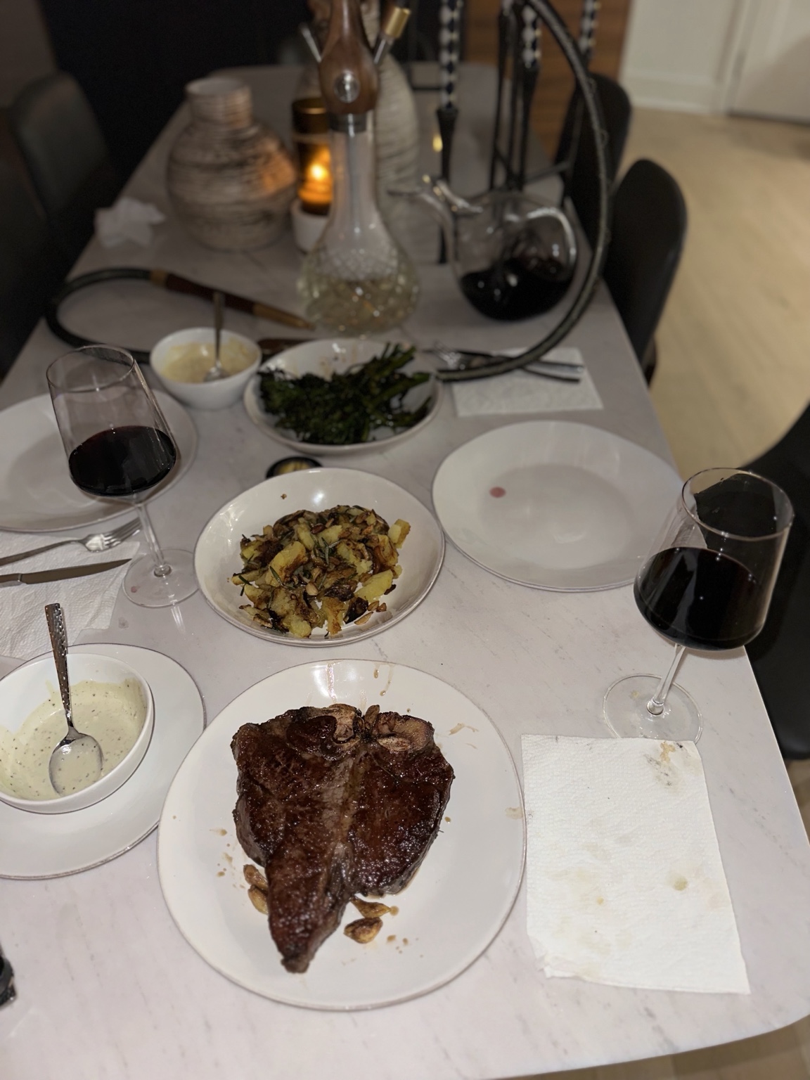 Seared T-bone steak with roasted potatoes, broccolini and herb sauce